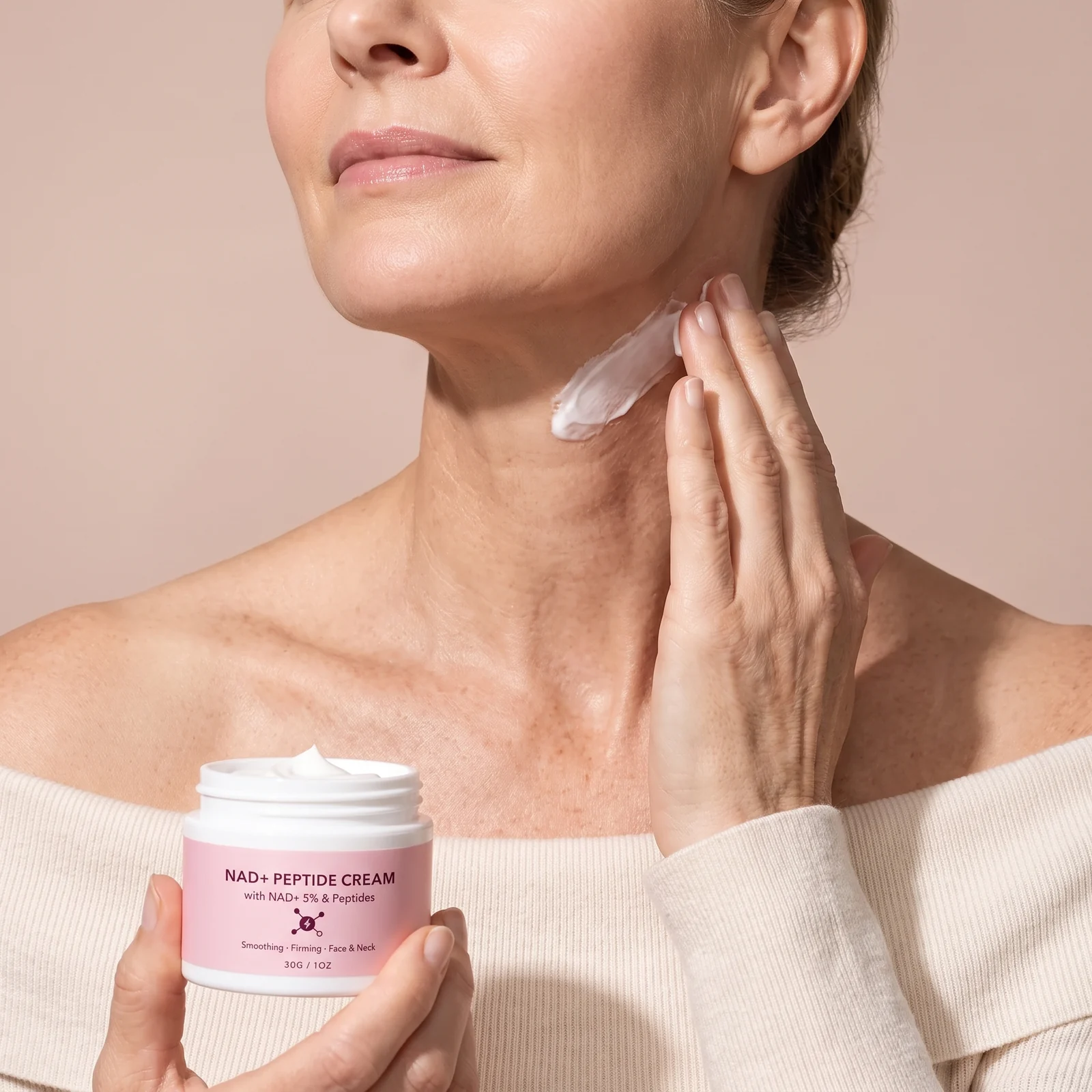 Woman smoothing the cream up her neck